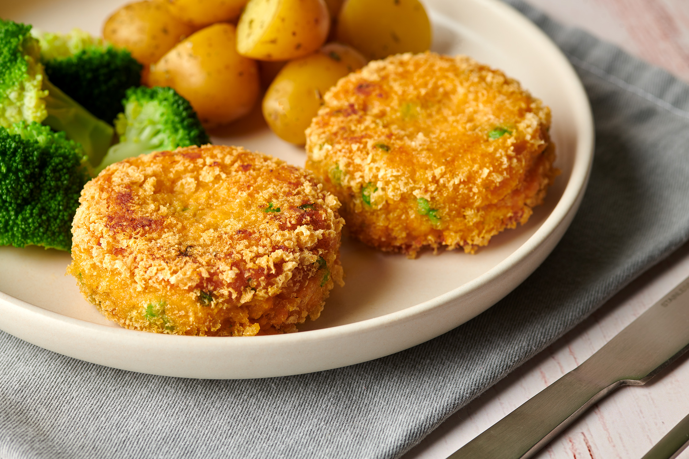 Crispy fish cakes with broccoli and new potatos